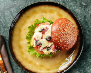 A comforting bowl of creamy hamburger casserole made with ground beef, cream of mushroom soup, and topped with melted cheese, served hot in a white dish.